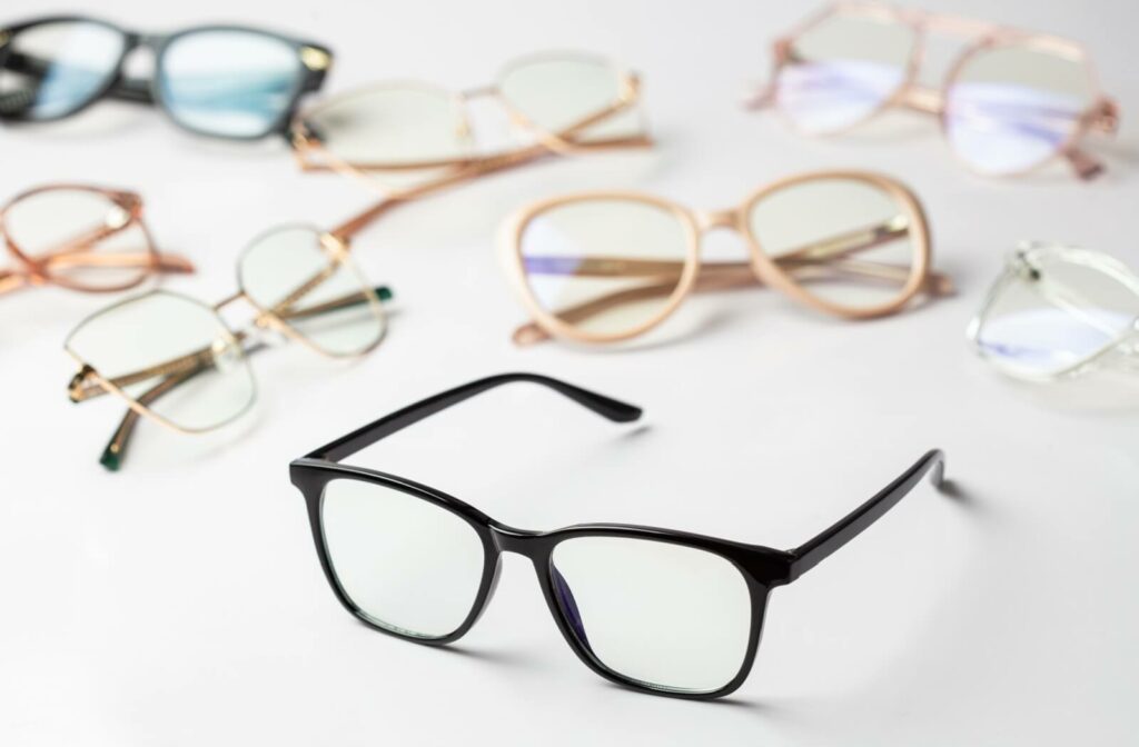 A collection of eyeglasses in different colours and patterns on display on a white table.
