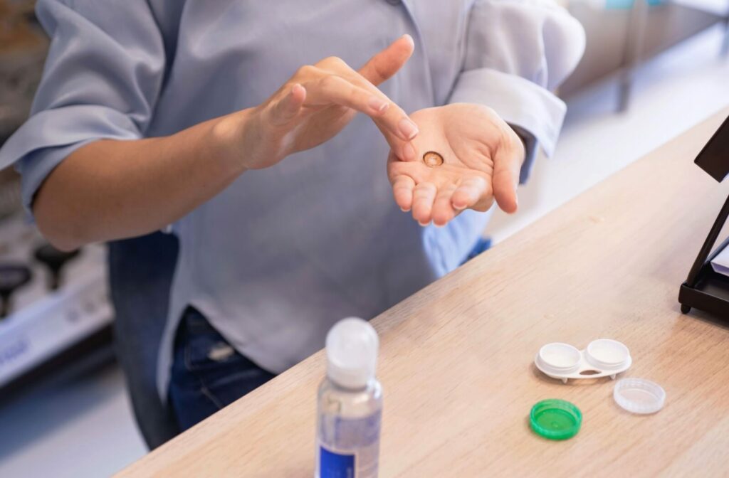 A patient cleaning their contact lens with saline solution to maintain proper lens care.