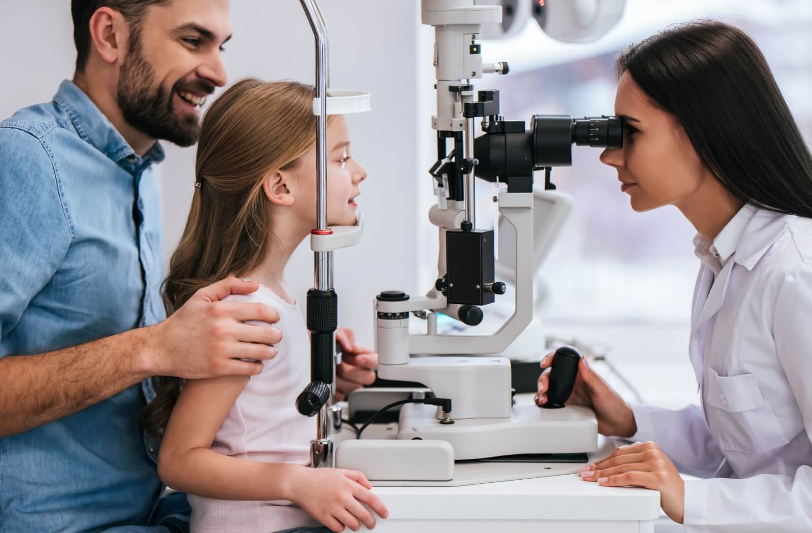 A child sitting on their parent's lap across from an optometrist during their OHIP eye exam.